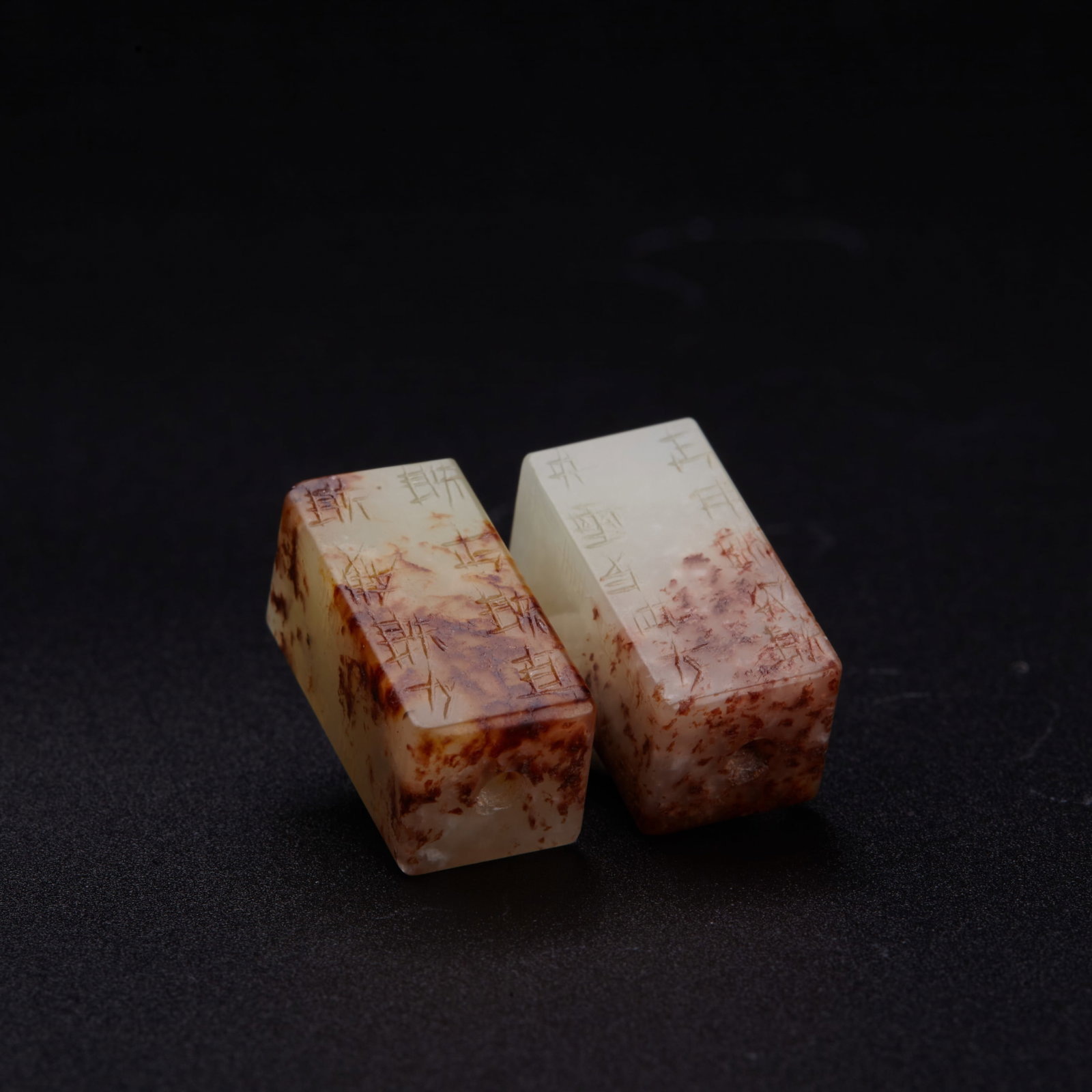 A pair of white and russet jade cubic pendant, probably Han Dynasty (private English collection): A pair of white and russet jade cubic pendant, probably Han Dynasty (private English collection) the cubic shaped pendants 'gang mao yan mao' inscribed on each side with ancient characters, used for r