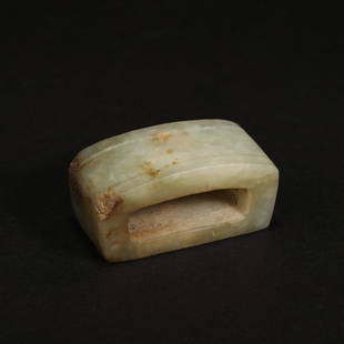 A celadon jade belt buckle, Qing Dynasty (private English collection): A celadon jade belt buckle, Qing Dynasty (private English collection) of rectangular section form slightly doomed on the top, hollowed out in the centre, the stone of celadon colour with even paler