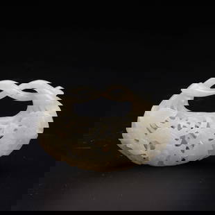 A white jade reticulated pouch-form carving, Qing Dynasty (Bonhams London): A white jade reticulated pouch-form carving, Qing Dynasty (Bonhams London) carved in openwork relief with exotic birds amongst a profusion of leafy, blossoming branches, rising to entwined stems