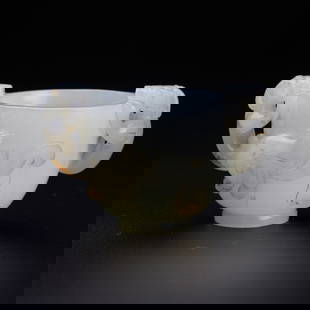 A white jade cup with dragon handles, Qing Dynasty (Lyon & Turnbull): A white jade cup with dragon handles, Qing Dynasty (Lyon & Turnbull) carved in high relief with two chi dragons clinging on the exterior with front paws and chins resting on the mouth rim of the
