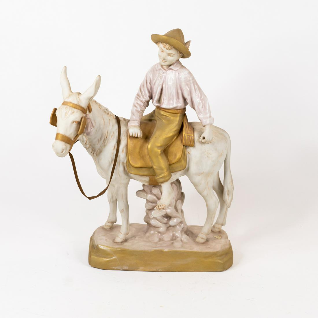 Royal Dux Porcelain Boy on Donkey Figurine: A porcelain Royal Dux figurine depicting a boy riding a donkey. Marked on the underside 'Royal Dux Czechoslovakia'