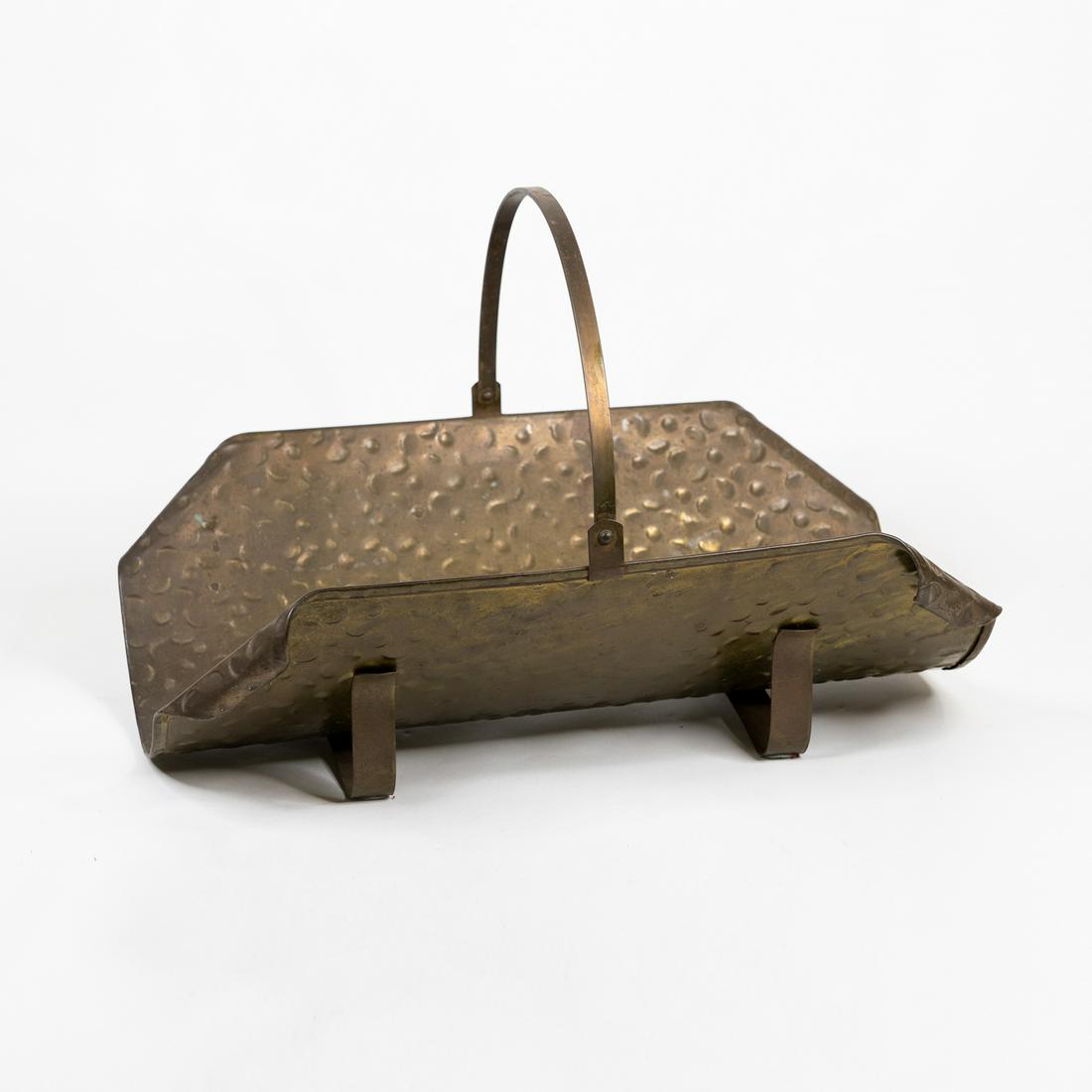 Hammered Brass Fireplace Log Basket: A footed hammered brass fireplace log carrier basket with a single handle and scrolled corners.