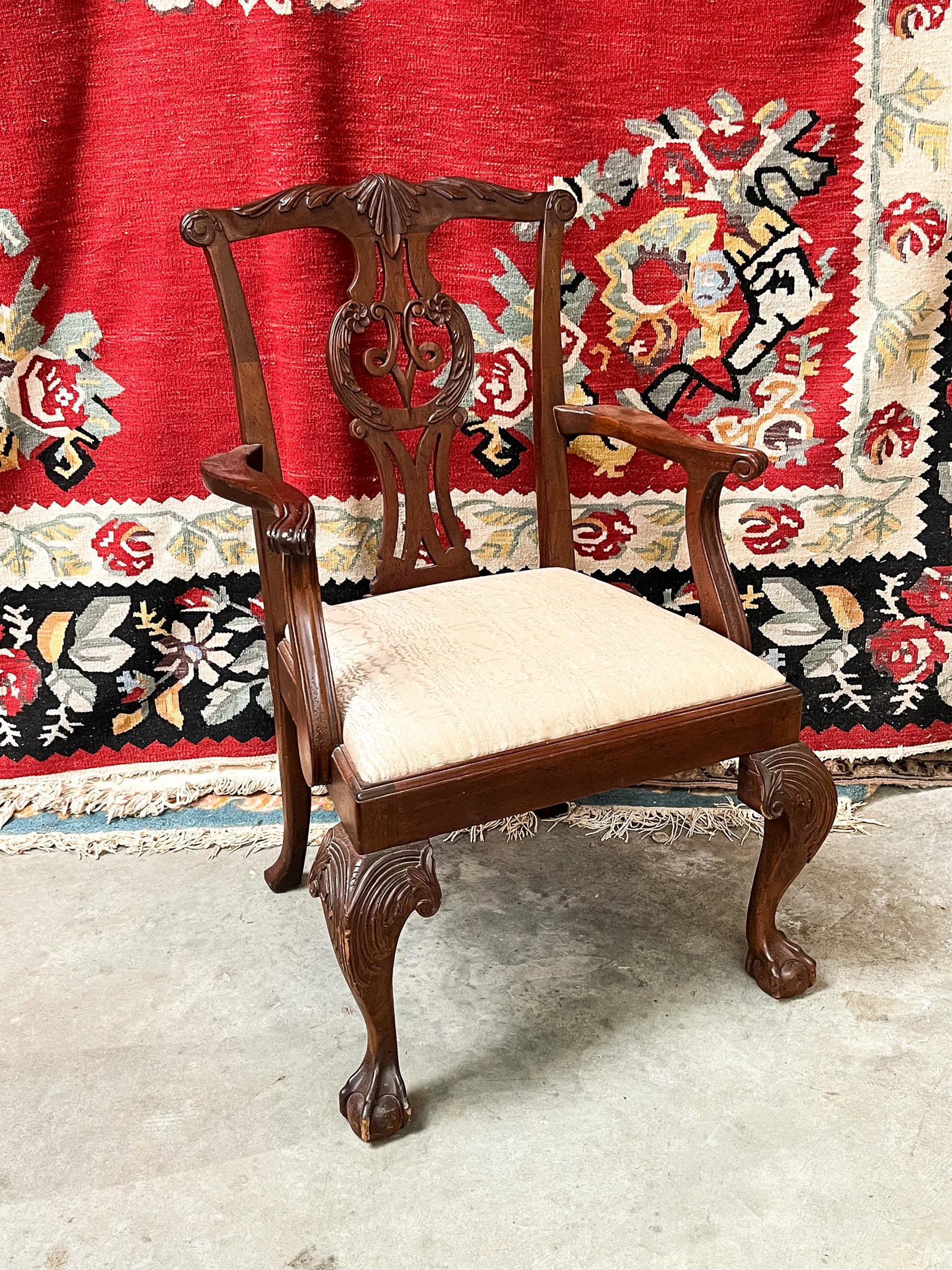 Baker Carved Mahogany Chippendale Armchair: A Baker furniture carved mahogany armchair having beige fabric upholstered cushion seat.