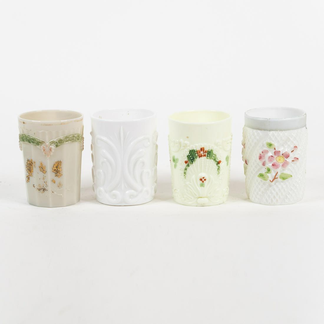 (4) Vintage Embossed Milk Glass Tumblers: A group of 4 vintage milk glass tumblers with various embossed floral, scroll, and shell motifs. Some have hand-painted details.