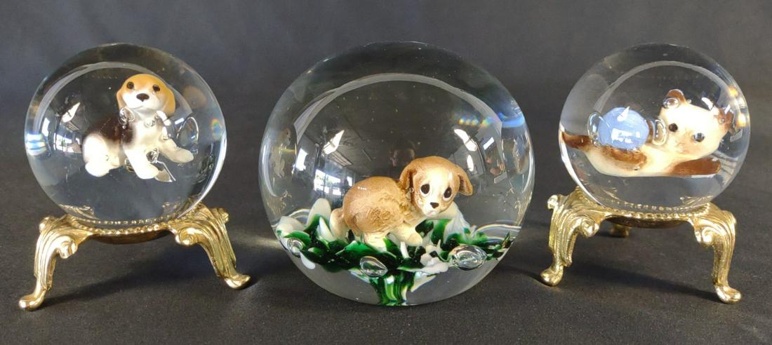 3 Gibson Glass Art Cat & Dog Paperweights: Made by Gibson Glass. Three handmade paperweights with puppies and cats encased in glass bubble. Stands not included. The larger puppy paperweight is stamped "Gibson 1993"