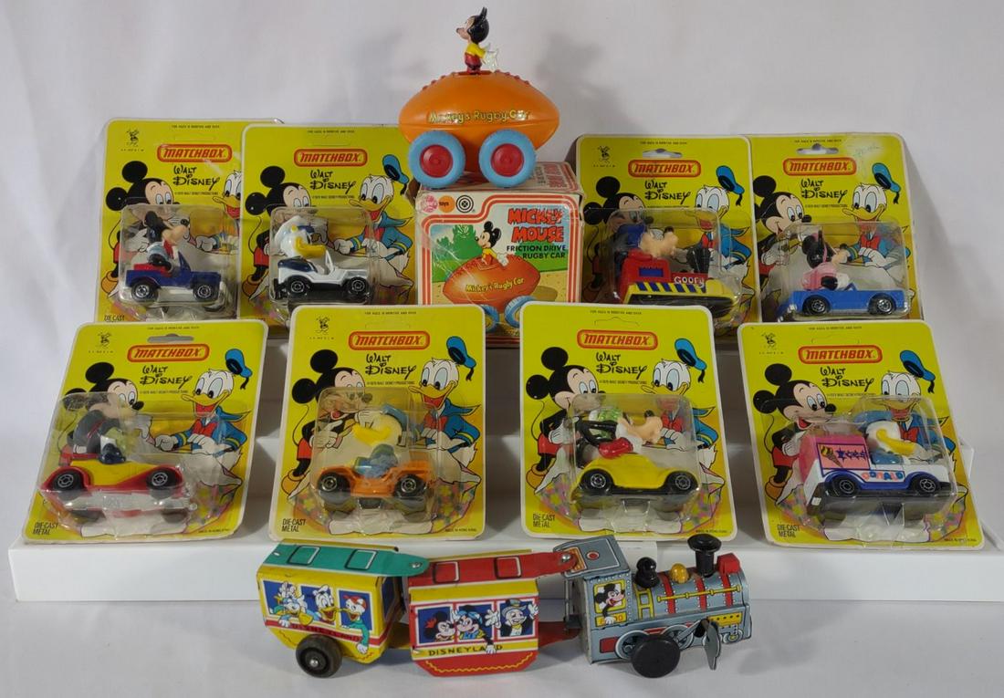 Vintage Disney Matchbox Cars, Tin Train & Toy Car: Includes 8 Walt Disney diecast matchbox cars in original packaging (1979 Lesney Productions). Marx Disneyland Express tin wind up train (works). Also includes Marx Toys Mickey Mouse friction drive rug