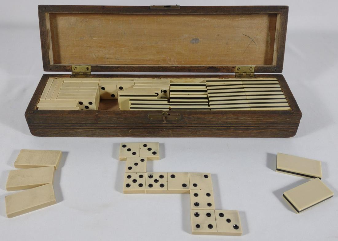 Antique Dominoes Game in Wooden Carved Box: Antique carved wooden dominoes box with working latch. Appears to have two sets of dominoes, one of which is bone.