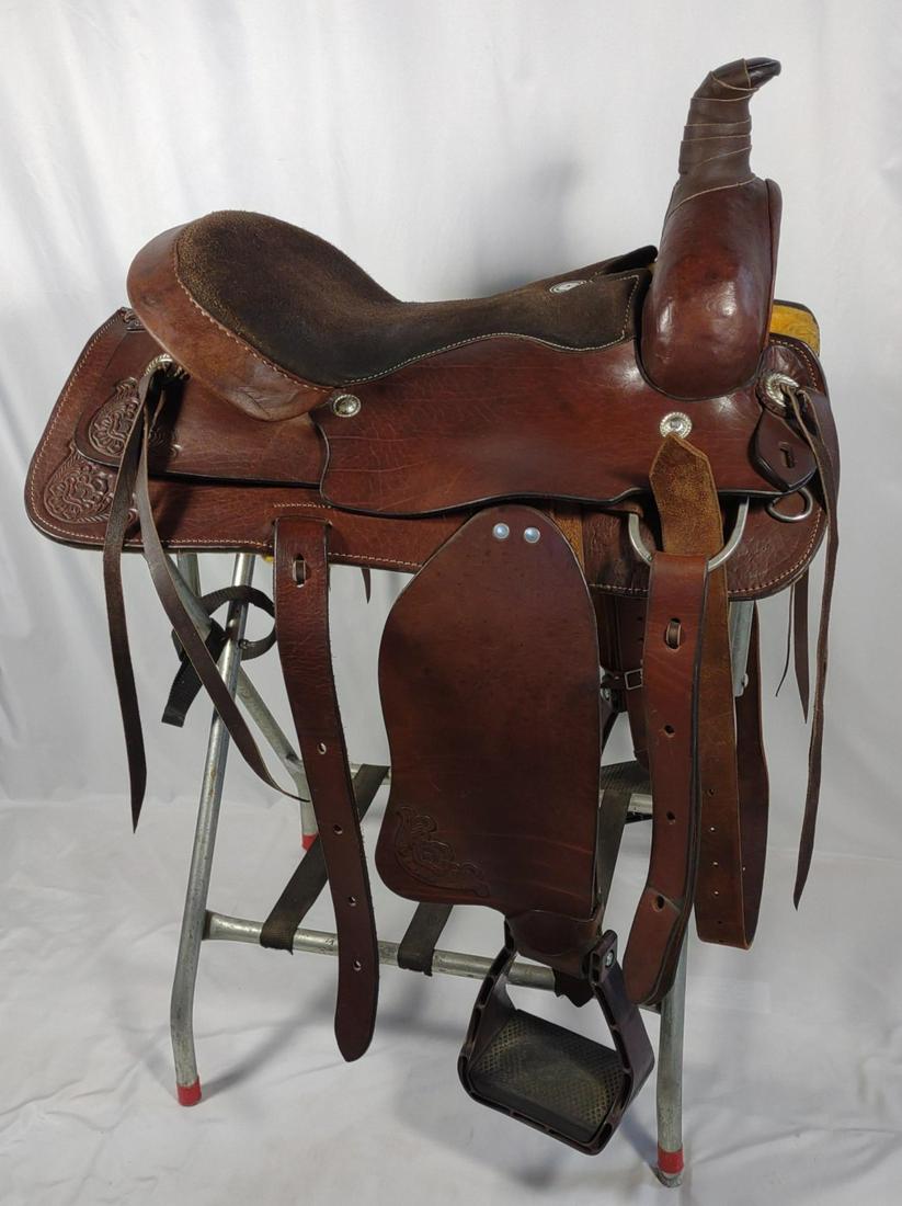 Buffalo Saddlery Roping Saddle #1951 17": Brown leather roping horse saddle custom made by Buffalo Saddlery. Suede seat with tooled leather trim. Stand is included with the saddle. We can remove stand from this lot if you are only interested 