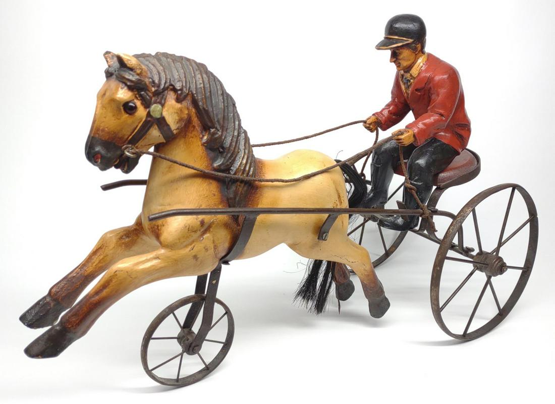 Vintage Sulky & Horse Figure 24": Vintage painted horse with jockey and sulky cart. This is a reproduction piece made with iron (cart), wood (seat), and cast painted material (Jockey and horse). A great decoration for equestrian colle