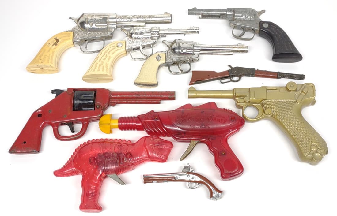 10 Vintage Toy Revolvers & Spark Guns: Includes western metal toy revolvers, red pressed steel toy revolver, Ringling Bros circus spark ray gun, and gold painted dummy luger.