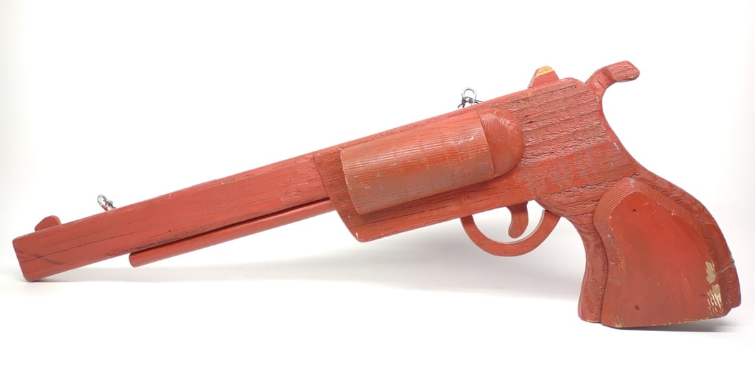 Gun Shop Trade Sign of Revolver (32" long): A red painted wooden revolver gun smith trade sign. Double sided with mounting hardware on topside. Marked "RFA #3 2002" on underside of grip. 32" in length.