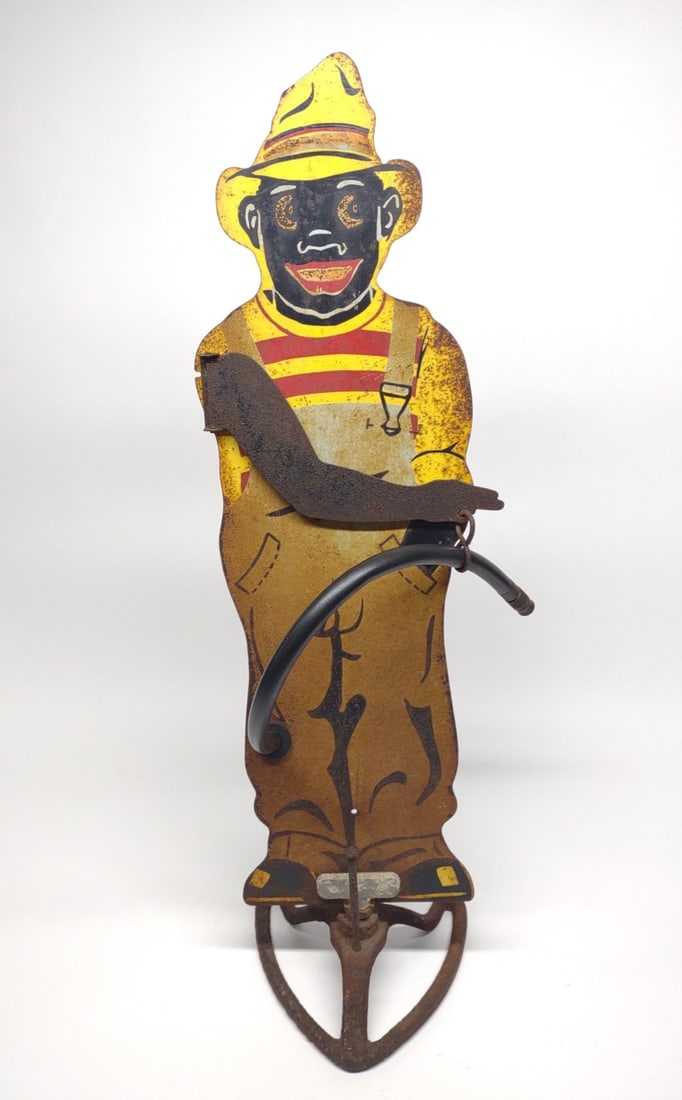 Vintage Sprinklin Sambo Metal Lawn Sprinkler: A vintage black americana die-cut metal lawn water sprinkler "Sprinklin Sambo" with original hose, bronze end, and cast iron base. Makers mark "Pla-Wood products Co". Surface rust present.