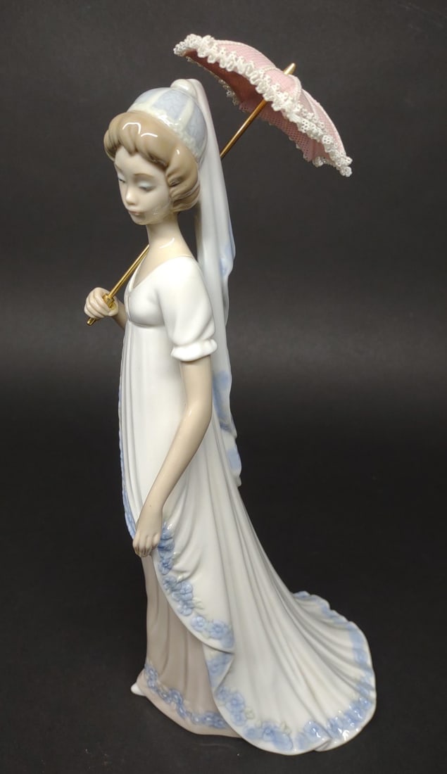 Lladro Viennese Lady #5322 Porcelain Figure: Lladro woman with umbrella figurine. #5322. Condition: Small cracks in top of umbrella. No other flaws, stands 11" tall.In-house International shipping NOT available for this item. UPS third party or