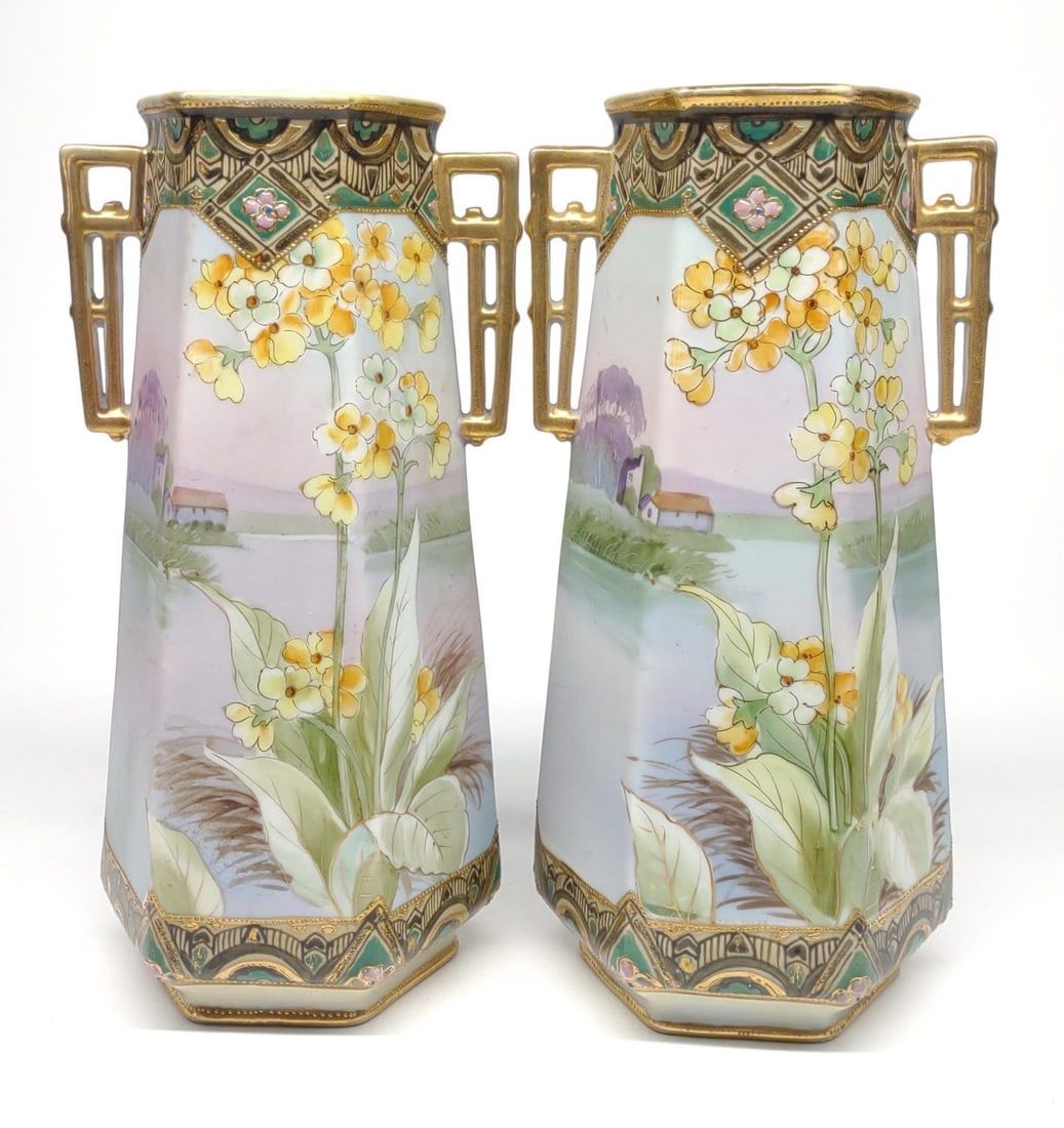 Pr of Nippon Jeweled Lake Scene Floral Vases: A pair of antique, circa late 19th/early 20th century, hand painted porcelain Japan Nippon double handled hexagonal vases. Both features a painting of a group of yellow and orange flowers growing by a
