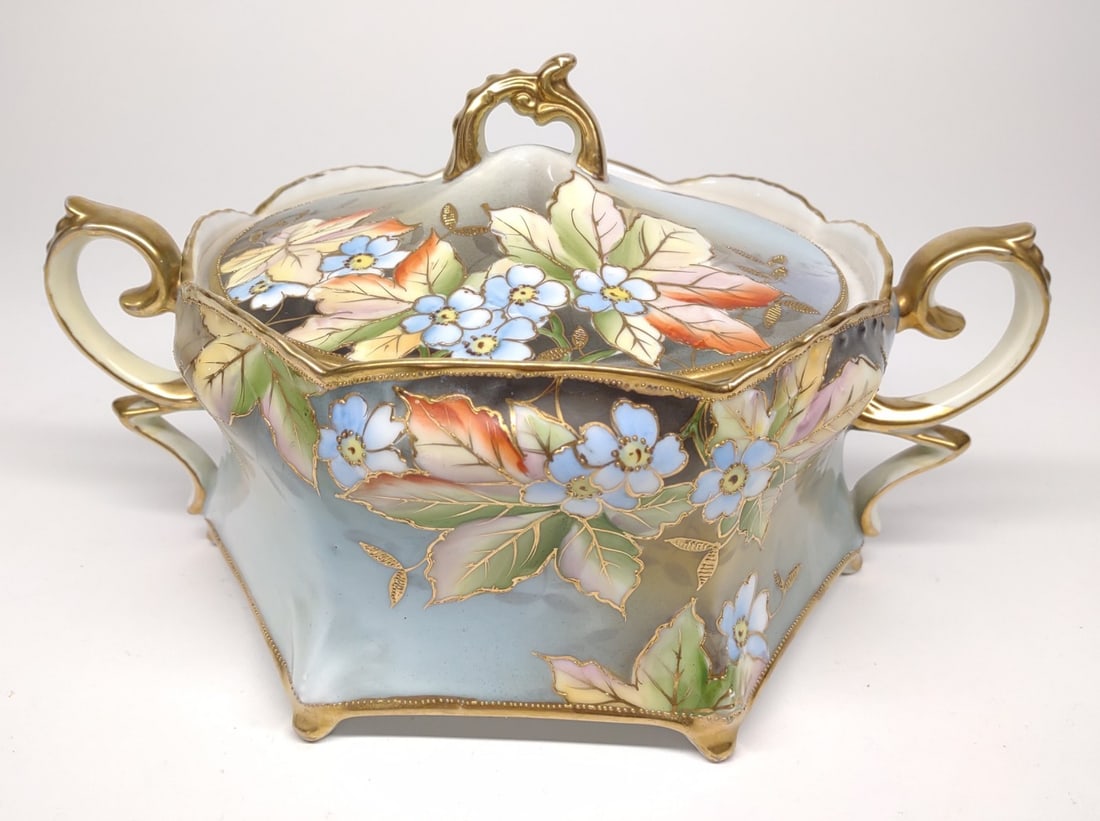 Nippon Blue Floral & Gold Cracker / Biscuit Jar: Antique, circa late 19th/early 20th century, hand painted porcelain Japan Nippon lidded double handled biscuit / cracker jar. Featuring blue flowers against a gradient background with orange and green