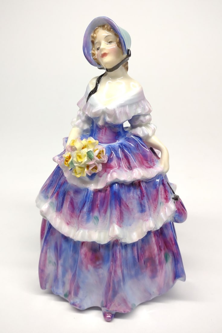 Royal Doulton figure Irene HN1952: Vintage, circa 1952 England, Royal Doulton figure Irene HN1952. Depicting a woman wearing blue and purple ruffled dress with matching bonnet and carrying a bouquet of flowers. Artist: Leslie Harradine
