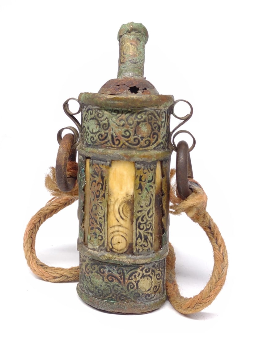 Antique Middle Eastern Powder Flask: Antique middle eastern metal and hand carved bone powder flask. Includes rope carry handle. Top neck piece has detached. Measures 6.75" tall.