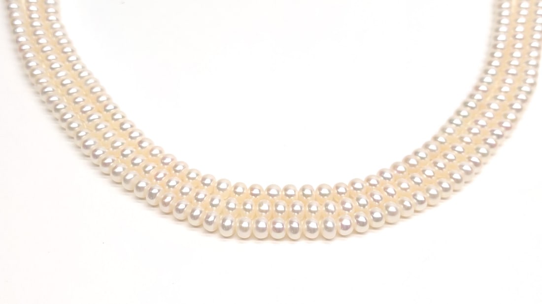 14K AAA Akoya 5mm Triple Strand Pearl Necklace: A high quality 14 karat yellow gold and akoya pearl beaded necklace. AAA grade, 5mm. 18" long. Marked "14K" with makers mark on clasp. Has been tested for purity. Total Weight: 56.19 grams.