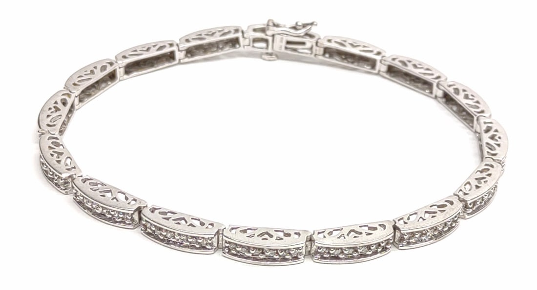10K White Gold & Diamond Tennis Bracelet (7" long): A 10 karat white gold diamond accented tennis bracelet. 7" long. Marked "10K" on clasp end. Has been tested for purity. Total Weight: 9.76 grams.