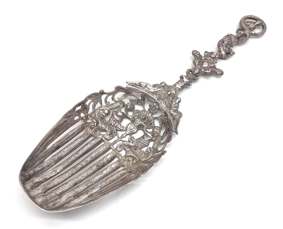 Antique Ornate Pierced Sterling Serving Spoon: An antique, 1800s, ornate pieced sterling silver serving spoon. Decorated with cherubs, serpents, and nude women. Marked with head facing left (front center handle), and "LLS" (front lower edge). Poss