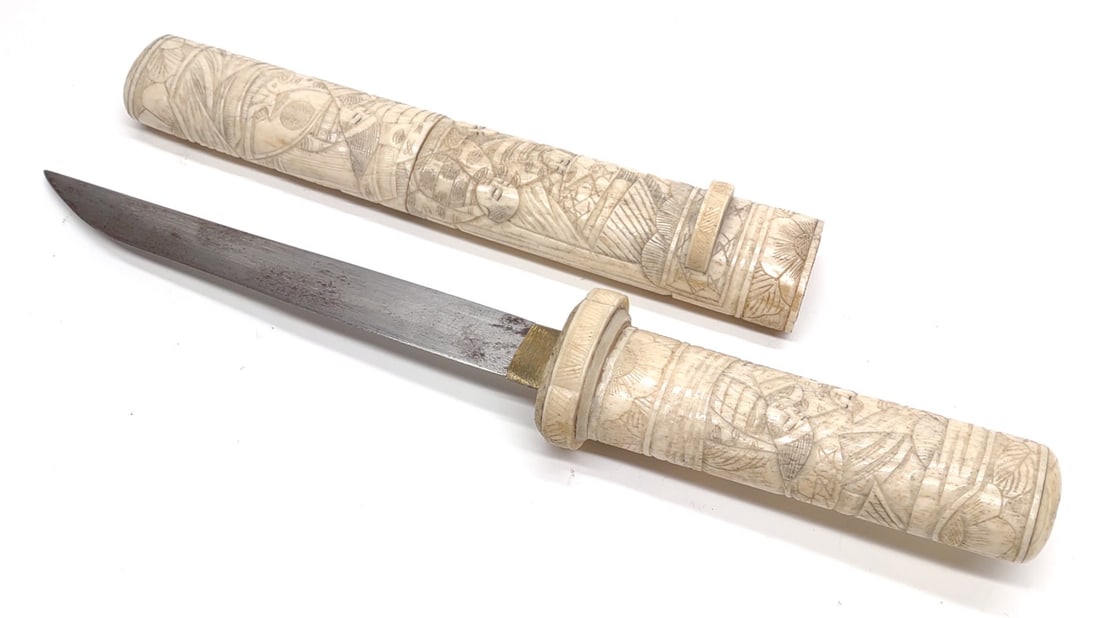 Antique Japanese Bone Tanto Dagger: Antique Japanese bone Tanto dagger. No markings present. Hand carved bone hilt and sheath. Blade measures approximately 6.25" long. Tanto dagger in sheath measures approximately 12.25" long.
