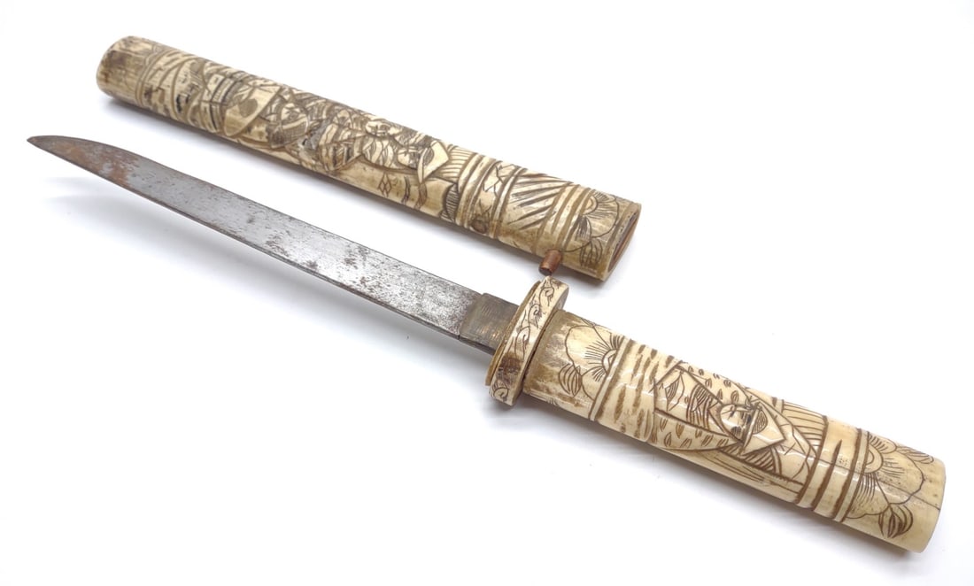 Antique Japanese Carved Bone Tanto Dagger: Antique Japanese carved bone Tanto dagger. No markings present. Hand carved bone hilt and sheath. Blade measures approximately 6.5" long. Tanto dagger in sheath measures approximately 12.25" long. Mea