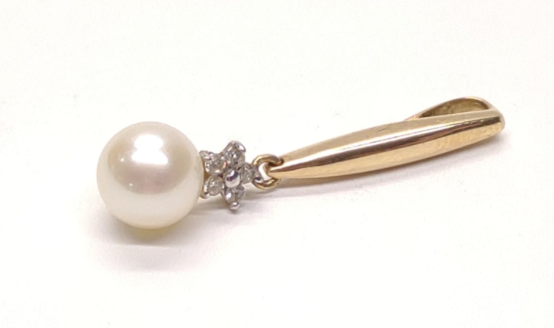 10K Yellow Gold Pearl & Diamond Drop Pendant: A vintage 10 karat yellow gold, diamond and pearl drop pendant. 6.8mm pearl, accented with 5 round diamonds in flower shape. Marked "10K". Tested for stones and purity. Total weight: 1.24 grams. SHIPP