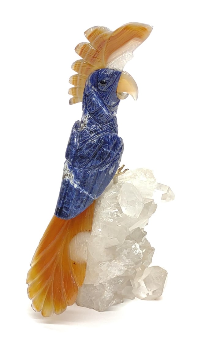 Semi Precious Stone Carved Cockatoo Sculpture: Sodalite and yellow quartz carved cockatoo sculpture / figure perched on quarts crystal geode. Bird sculpture features intricately carved feather designs and metal feet that mounts sculpture to geode.