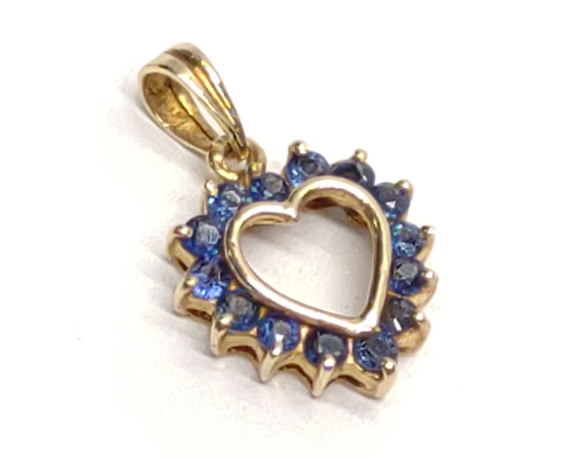 14K Yellow Gold Blue Sapphire Heart Pendant: 14 karat yellow gold heart shaped necklace pendant with 14 round cut prong set blue sapphires (0.7 cttw). Pendant is marked "14K" with makers mark "EJ". Has been tested for gold purity and stones. Tot