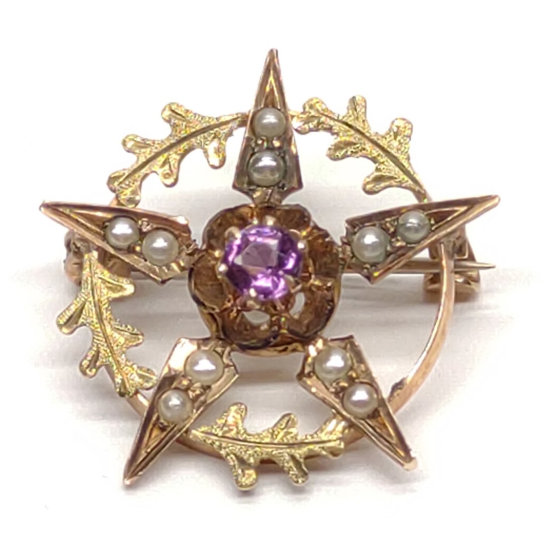 Edwardian 10K Gold Amethyst & Pearl Brooch Pendant: An antique, Edwardian, 10 karat yellow gold, amethyst adn seed pearl star brooch / necklace pendant. Features round cut amethyst surrounded by seed pearls in a star form setting. C clasp pin with pend