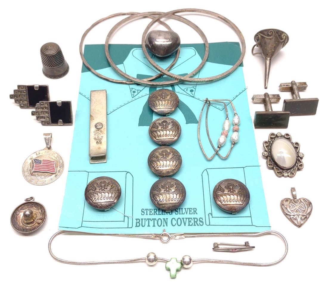 17 Sterling Silver Jewelry Pieces: A group of 17 vintage sterling silver jewelry items. Includes pendants, bracelets, button covers, thimble, earring sets, cufflink, and bar pin. Most are marked with sterling silver markings and makers