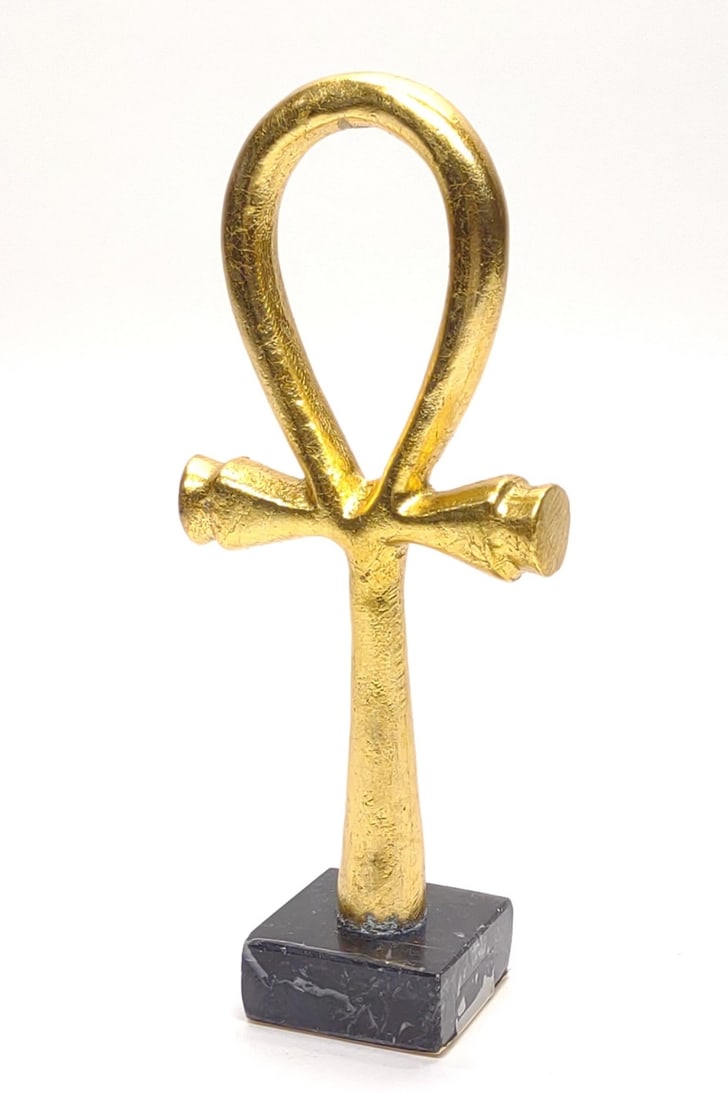 Egyptian Ankh 24k Gold Leaf Sculpture: Vintage Egyptian Ankh sculpture. Sculpture is decorated with a 24 karat gold leaf paint and stands on a black marble style base. Underside is marked "Ankh" with brief description of sculpture on under