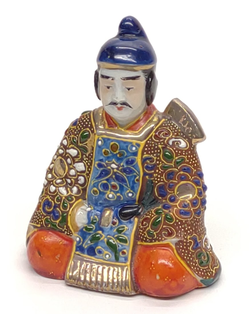Japanese Kutani Moriage Samurai Figurine: Kutani (porcelain) samurai figurine, Japan. Figure depicts a Samurai in a seated position, featuring colorful Moriage enamel decoration with gold accents. Measures approx. 3 1/2 x 3 x 2 in. SHIPPING O