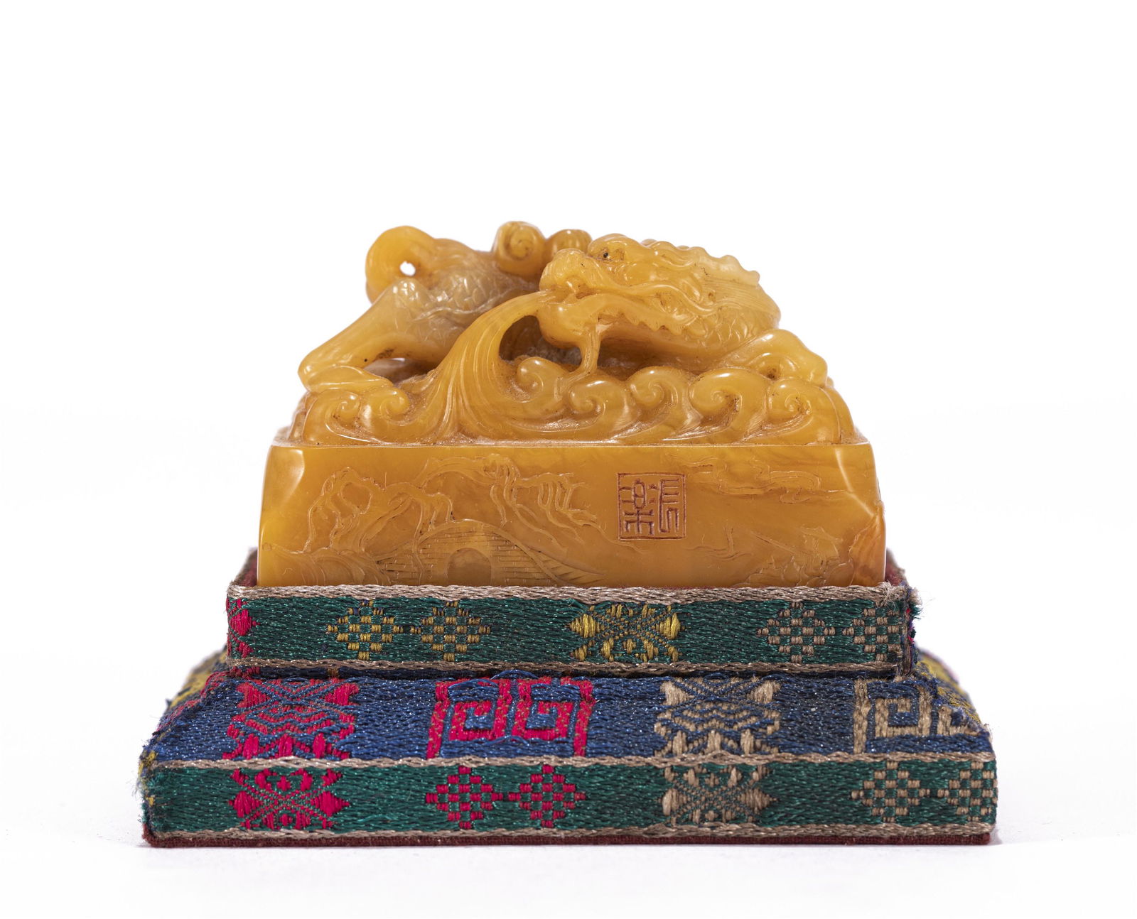 A CHINESE CARVED TIANHUANG DRAGON SEAL: A CHINESE CARVED TIANHUANG DRAGON SEAL The rectangular seal is surmounted by a finely detailed dragon spiting stream, the stone is of rich amber tone. DIMENSIONS: 2 5/6 in x 1 2/3 in x 1 2/3 in (L. 7