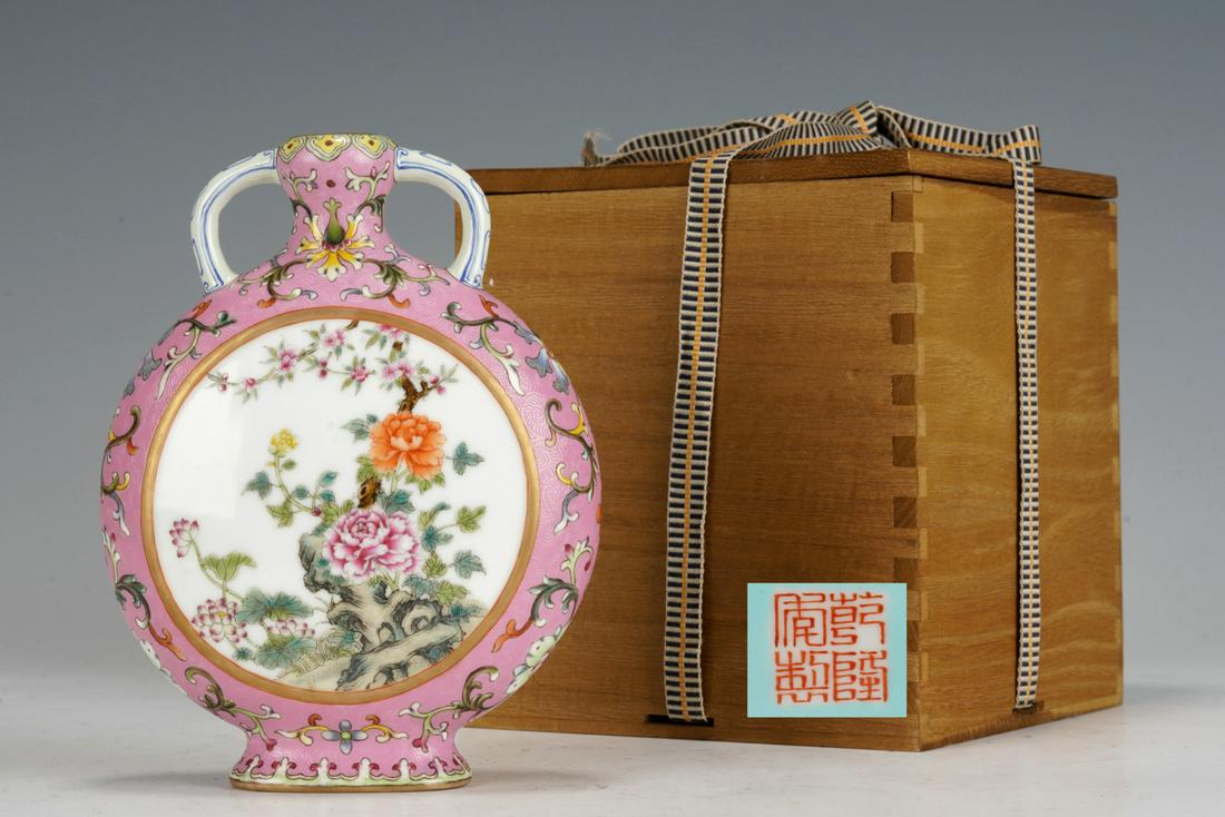 A CHINESE FAMILLE ROSE PEONY MOON FLASK: A CHINESE FAMILLE ROSE PEONY MOON FLASK The flattened globular body rising from a short oval foot to a slender neck flanked by a pair curved handles, painted on each side with peony in garden in Fami