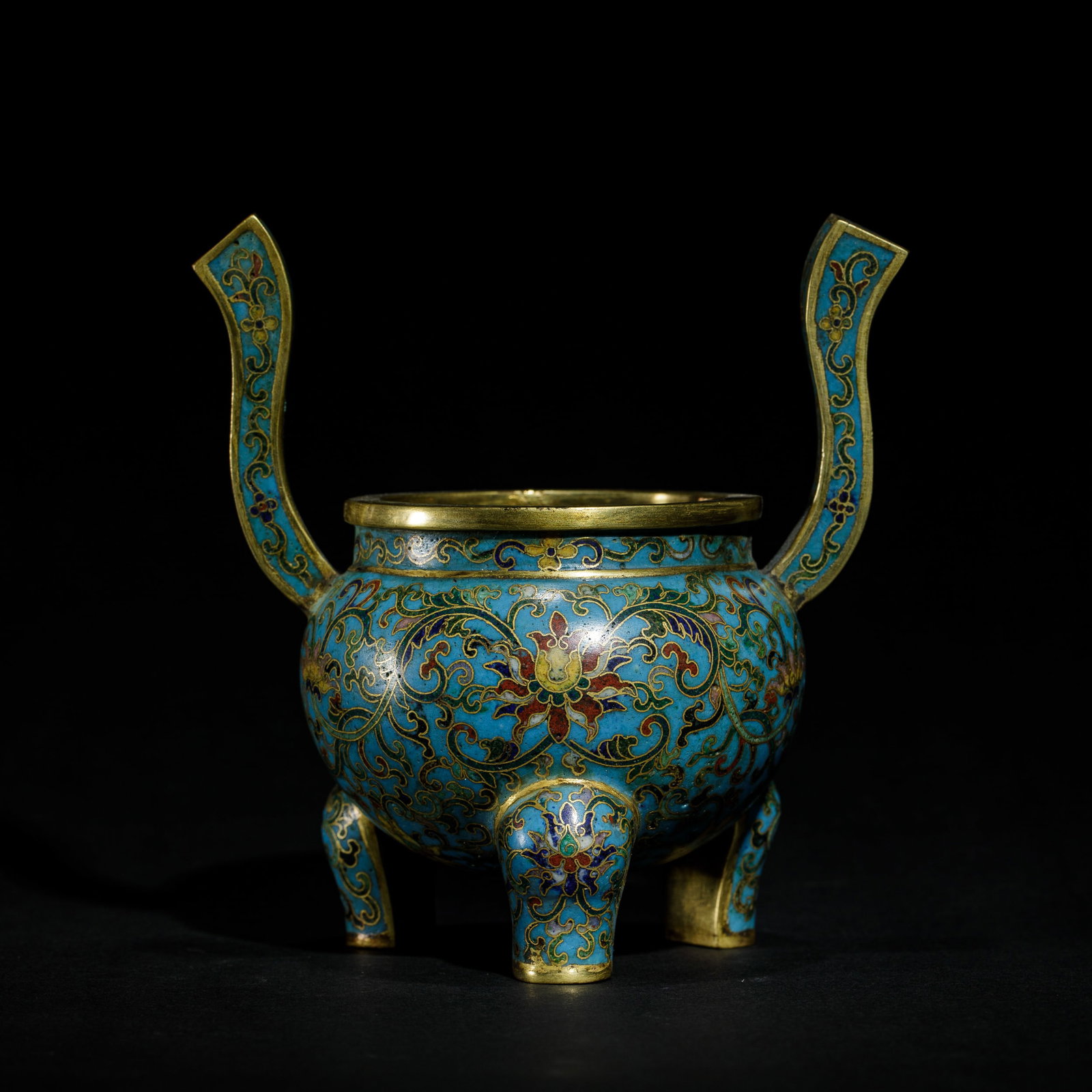 A CHINESE CLOISONNE ENAMEL TRIPOD CENSER: A CHINESE CLOISONNE ENAMEL TRIPOD CENSER The censer is decorated to each side with a lotus heads on scrolling foliage. The recessed neck, twin upright handles and cabriole legs are similarly decorated