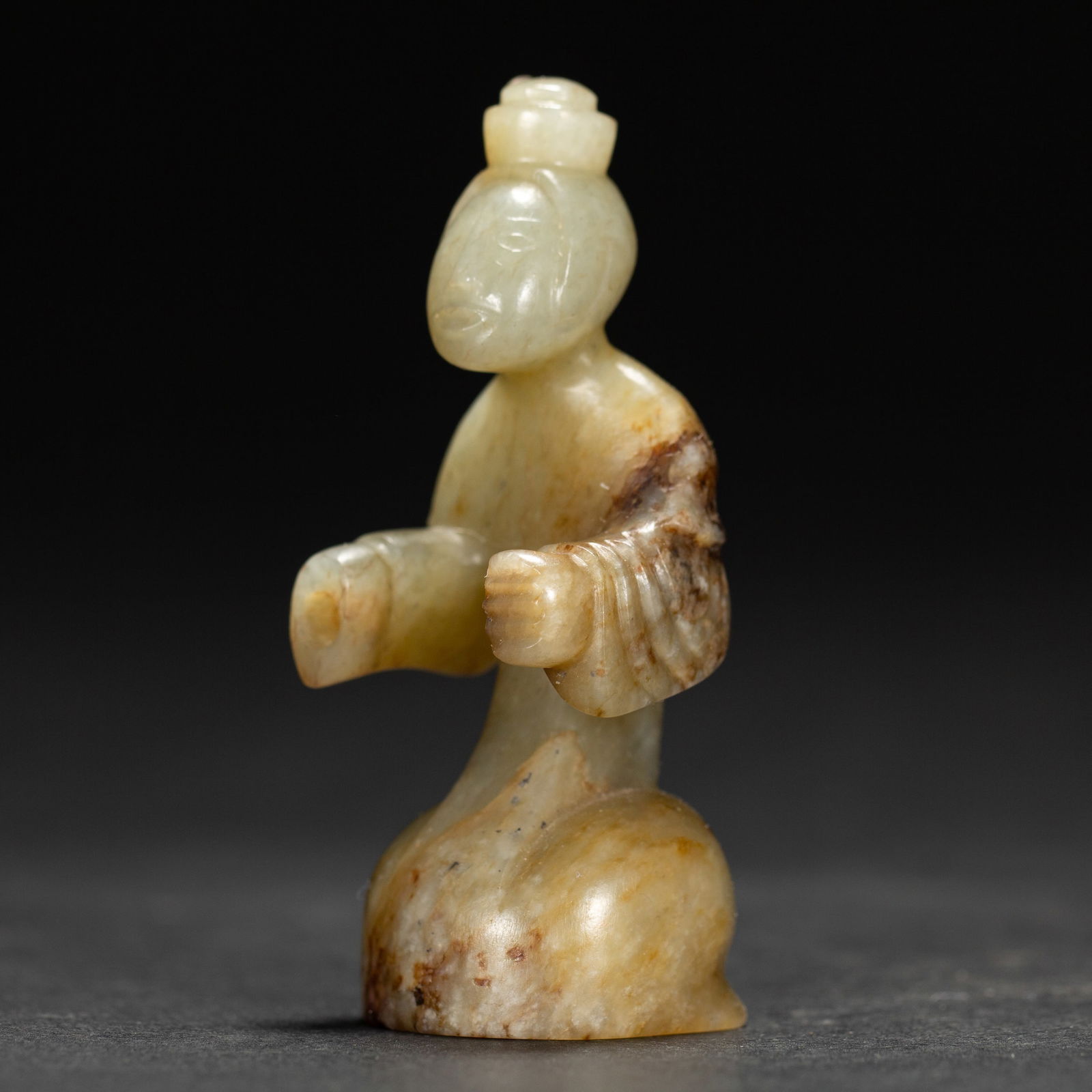 A JADE CARVING OF FIGURE: A JADE CARVING OF FIGURE The kneeling figure wearing long robe, the stone is of warm white tone with russet speckles. DIMENSIONS:L. 2.5 cm. W. 2.5 cm. H. 6.5 cm. Weight 40 grams. HAVE A SIMILAR ITEM T