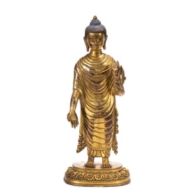 A BRONZE-GILT STANDING BUDDHA