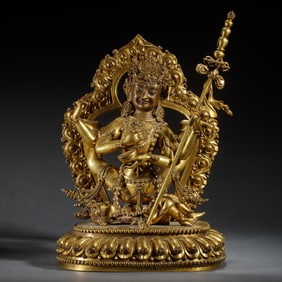 A BRONZE-GILT SEATED PROTECTOR