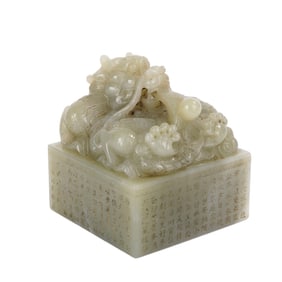A CARVED AND INSCRIBED WHITE JADE DRAGON SEAL