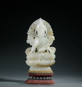 A CARVED WHITE JADE SEATED GUANYIN