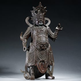 A BRONZE STANDING GUARDIAN