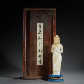 A CARVED JADE STANDING BUDDHA