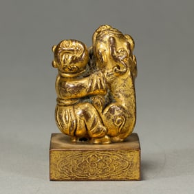 A BRONZE-GILT BOY WITH BEAST SEAL