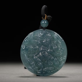 A CARVED JADEITE PENDANT OF PROTECTOR