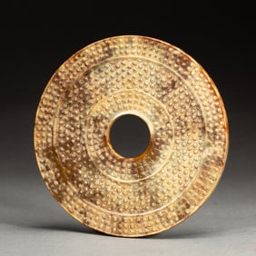 AN ARCHAISTIC CARVED DISC BI