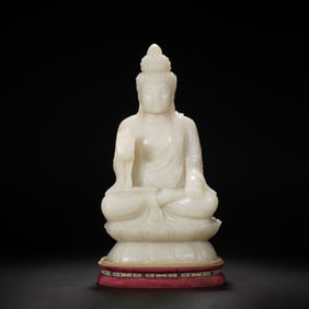 A CARVED WHITE JADE SEATED BUDDHA