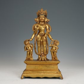 A RARE BRONZE-GILT STANDING DEITY WITH ACOLYTES