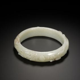 A CARVED WHITE JADE DRAGON BANGLE