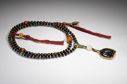 A TIBETAN DZI BEAD NECKLACE WITH AMULET BOX